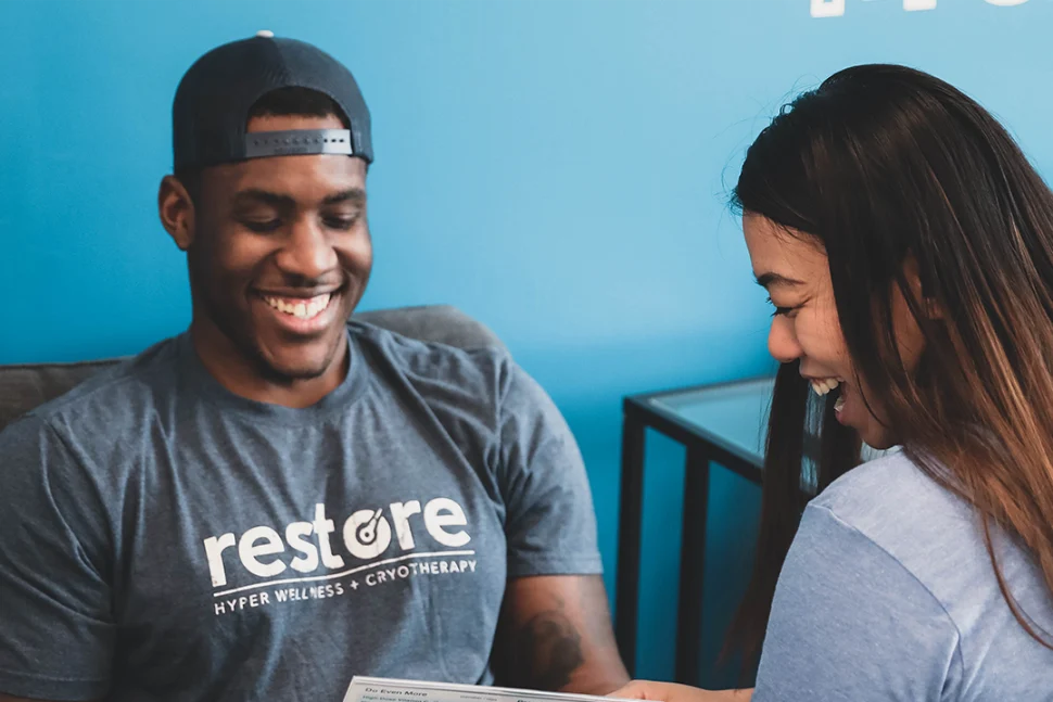 Man and woman smiling while looking at a pamphlet.