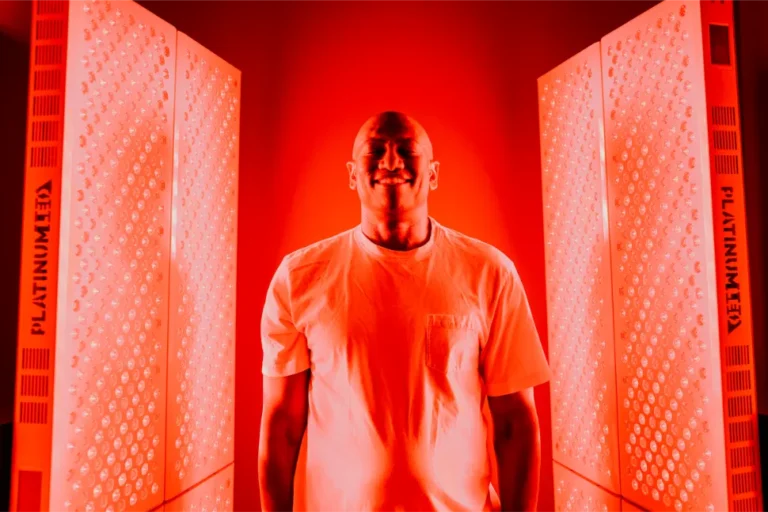 Man in white shirt get red light therapy.